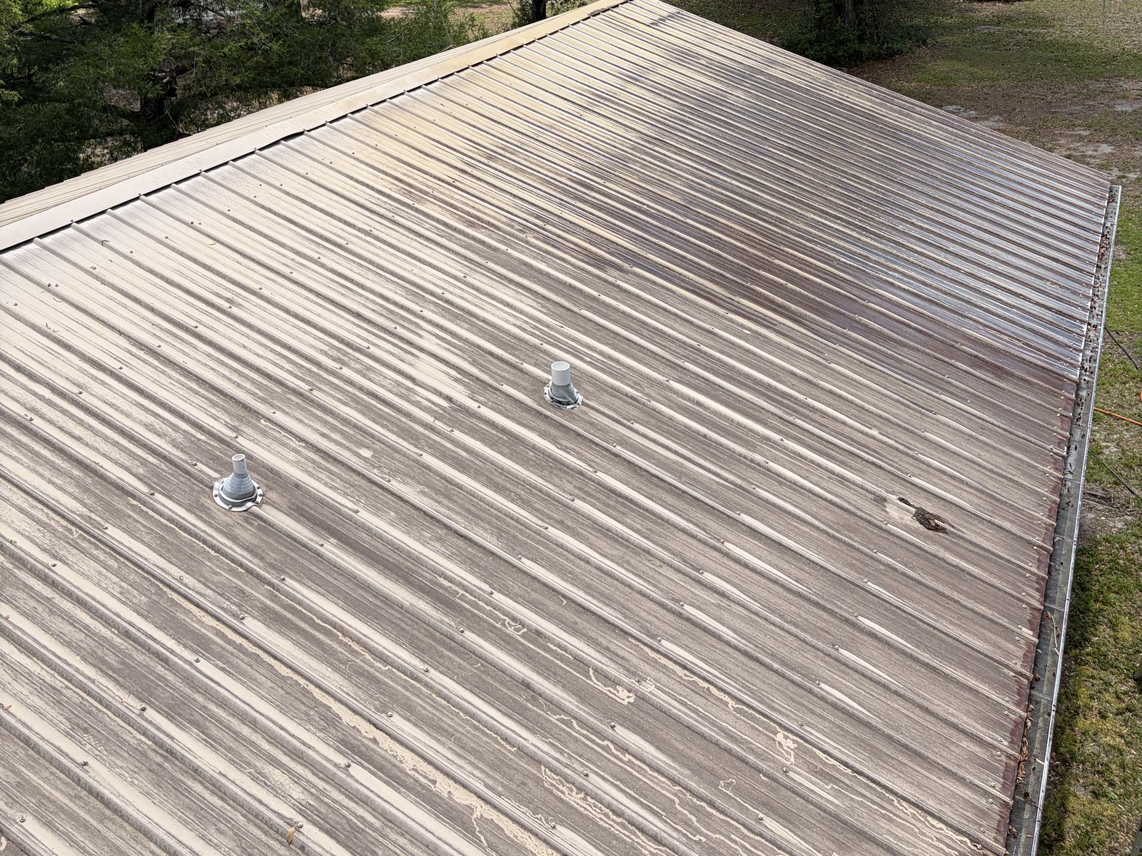 Metal roof panels streaked and weathered before soft wash roof washing