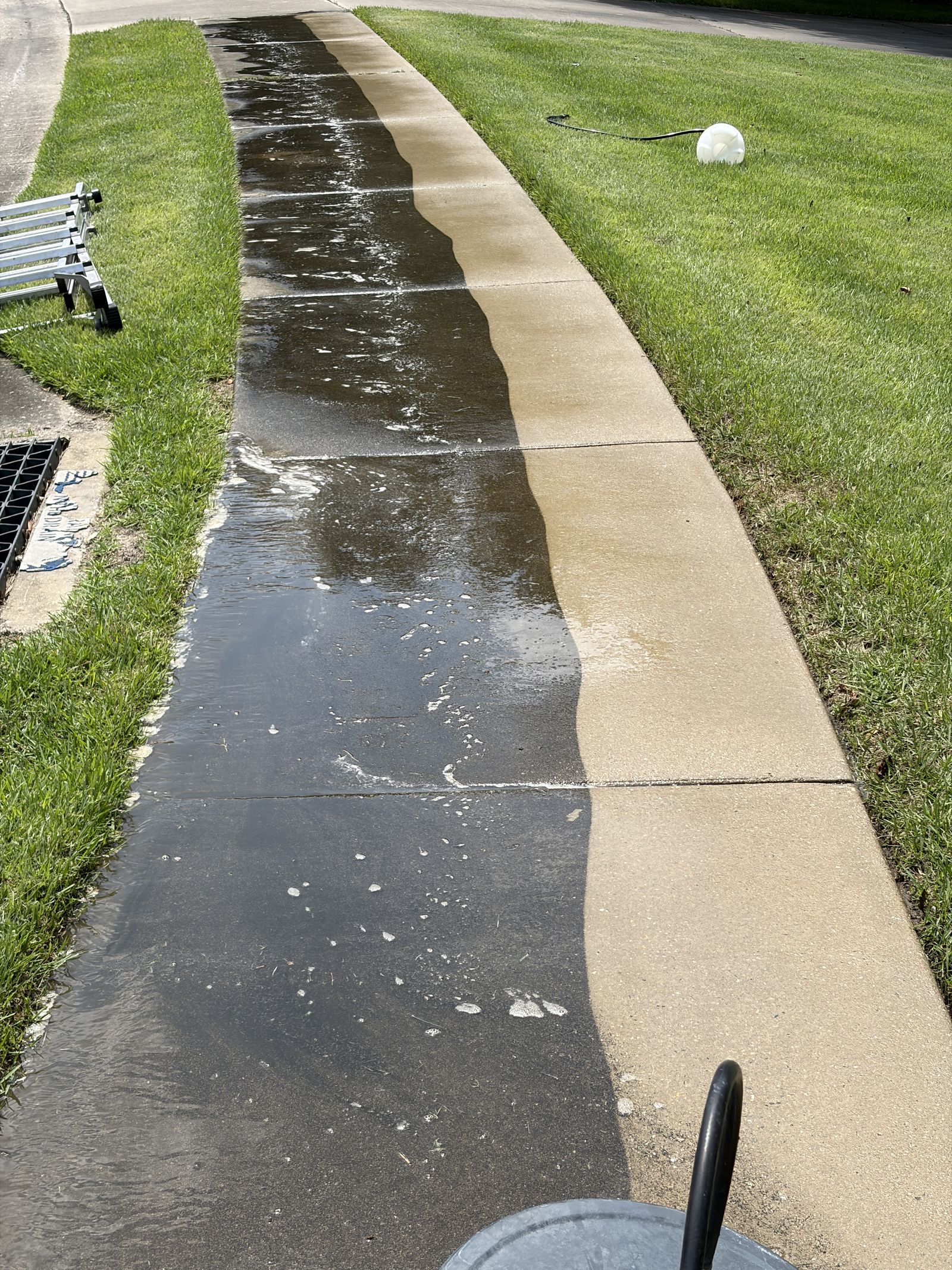 Pressure washed concrete showing the clean line against untreated surface