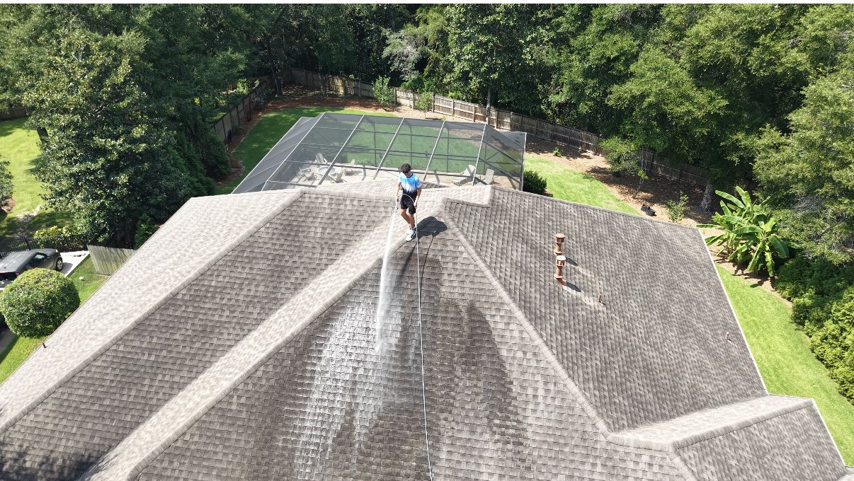 Wave Force technician soft washing an asphalt shingle roof, seen from above